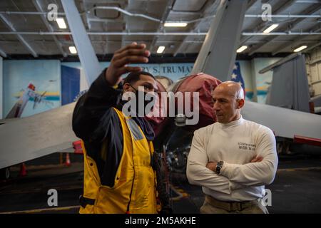 220216-N-ZE328-1250 MITTELMEER (16. Februar 2022) Fleet Master Chief Derrick Walters, Fleet Master Chief der USA Marine Forces Europe and Africa, right, spricht mit Aviation Boatswain's Mate (Handling) 2. Class Isaac Willabustner aus Nashville, Tennessee, in der Hangarbucht des Flugzeugträgers der Nimitz-Klasse USS Harry S. Truman (CVN 75), 16. Februar 2022. Die Harry S. Truman Carrier Strike Group befindet sich in einem geplanten Einsatz in den USA Sechstes Flottengebiet zur Unterstützung von Marineeinsätzen, um die maritime Stabilität und Sicherheit aufrechtzuerhalten und die Interessen der USA, Verbündeten und Partner zu verteidigen Stockfoto