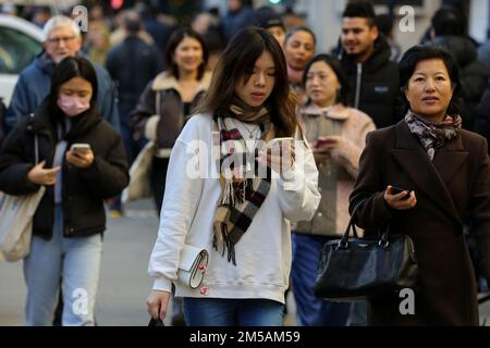 London, Großbritannien. 26. Dezember 2022. Frauen, die ihr Handy benutzen, während sie auf der Oxford Street im Zentrum Londons spazieren. (Kreditbild: © Dinendra Haria/SOPA Bilder über ZUMA Press Wire) Stockfoto