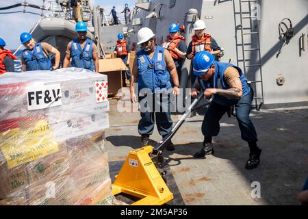 SÜDCHINESISCHES MEER (16. Februar 2022) Logistikspezialist 3. Klasse Carl Joseph Depaula aus Houston transportiert eine Palette von Vorräten an Bord des Arleigh Burke-Klasse-Guided-Raketenzerstörers USS Ralph Johnson (DDG 114) während einer Wiederauffüllung auf See mit dem Trockenfrachtschiff der Lewis- und Clark-Klasse USNS Amelia Earhart (T-AKE-6). Ralph Johnson ist der Task Force 71/Destroyer Squadron (DESRON) 15, dem größten nach vorn verlegten DESRON der Marine, und der Hauptstreitkraft der US-7.-Flotte zugewiesen. Stockfoto