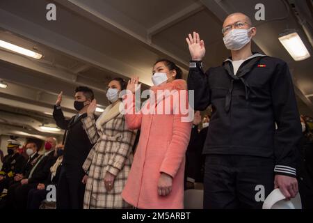 220217-N-SI601-1202 YOKOSUKA, Japan (17. Februar 2022) während einer Einbürgerungszeremonie in der Prognose der USA leisten die Kandidaten den Eid der Staatsbürgerschaft Der einzige vorwärtsgesetzte Flugzeugträger der Navy USS Ronald Reagan (CVN 76). Während der Zeremonie wurden 17 Kandidaten aus 11 verschiedenen Ländern amerikanische Staatsbürger, und der ehrenwerte US-Botschafter Rahm Emanuel in Japan diente als Hauptredner. Ronald Reagan, das Flaggschiff der Carrier Strike Group 5, stellt eine kampfbereite Truppe bereit, die die Vereinigten Staaten schützt und verteidigt und Bündnisse, Partnerschaften und kollektive maritime int unterstützt Stockfoto