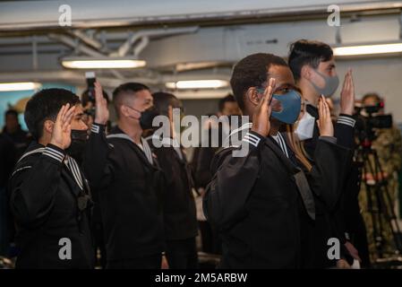 220217-N-DW158-1031 YOKOSUKA, Japan (17. Februar 2022) während einer Einbürgerungszeremonie in der Prognose der USA leisten die Kandidaten den Eid der Staatsbürgerschaft Der einzige vorwärtsgesetzte Flugzeugträger der Navy USS Ronald Reagan (CVN 76). Während der Zeremonie wurden 17 Kandidaten aus 11 verschiedenen Ländern amerikanische Staatsbürger, und der ehrenwerte US-Botschafter Rahm Emanuel in Japan diente als Hauptredner. Ronald Reagan, das Flaggschiff der Carrier Strike Group 5, stellt eine kampfbereite Truppe bereit, die die Vereinigten Staaten schützt und verteidigt und Bündnisse, Partnerschaften und kollektive maritime int unterstützt Stockfoto