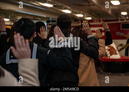 220217-N-DW158-1023 YOKOSUKA, Japan (17. Februar 2022) während einer Einbürgerungszeremonie in der Prognose der USA leisten die Kandidaten den Eid der Staatsbürgerschaft Der einzige vorwärtsgesetzte Flugzeugträger der Navy USS Ronald Reagan (CVN 76). Während der Zeremonie wurden 17 Kandidaten aus 11 verschiedenen Ländern amerikanische Staatsbürger, und der ehrenwerte US-Botschafter Rahm Emanuel in Japan diente als Hauptredner. Ronald Reagan, das Flaggschiff der Carrier Strike Group 5, stellt eine kampfbereite Truppe bereit, die die Vereinigten Staaten schützt und verteidigt und Bündnisse, Partnerschaften und kollektive maritime int unterstützt Stockfoto