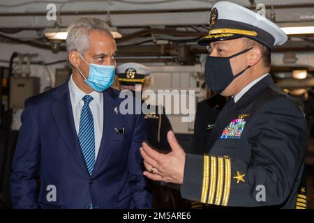 220217-N-SI601-1030 YOKOSUKA, Japan (17. Februar 2022) Kapitän Fred Goldhammer, Befehlshaber, spricht mit dem ehrenwerten US-Botschafter Rahm Emanuel in Japan in der Hangarbucht der USA Der einzige vorwärtsgesetzte Flugzeugträger der Navy USS Ronald Reagan (CVN 76). Während seines Besuchs besichtigte Emanuel Ronald Reagan, sprach vor der Crew und war Hauptredner bei einer Einbürgerungszeremonie, bei der 17 Kandidaten aus 11 verschiedenen Ländern amerikanische Staatsbürger wurden. Ronald Reagan, das Flaggschiff der Carrier Strike Group 5, stellt eine kampfbereite Truppe bereit, die den United Stat schützt und verteidigt Stockfoto