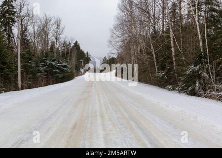 Base Station Road in Crawford's Purchase, New Hampshire, im Wintermonat Januar mit Schnee bedeckt. Das Skigebiet Bretton Woods liegt in der Dista Stockfoto