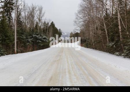 Base Station Road in Crawford's Purchase, New Hampshire, im Wintermonat Januar mit Schnee bedeckt. Das Skigebiet Bretton Woods liegt in der Dista Stockfoto