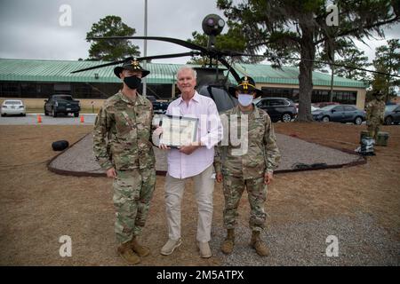 Oberstleutnant Jeffrey Paulus (links) und Oberstleutnant Edgard Gonzalez (rechts), Kommandeur und Kommandant Major der 3. Staffel, 17. Kavallerie-Regiment, 3. Kampfluftfahrtbrigade, 3. Infanteriedivision, präsentiert Lothar „Joe“ Funke mit dem „Orden der Goldspur“ am Hunter Army Airfield, Georgia, 17. Februar. Funke erhielt seine Goldsporne 50 Jahre, nachdem er im Vietnamkrieg von 1968-1969 gedient hatte. Der „Orden der Spur“ ist eine zeitlose Kavallerie-Tradition, die es Soldaten ermöglicht, Goldsporne zu verdienen, indem sie im Kampf dienen, oder Silbersporne zu verdienen, indem sie erfolgreich eine Einheit-Sporenfahrt abschließen. Stockfoto