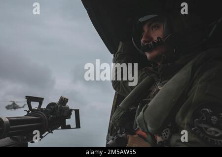 USA Angel Hernandez, ein Chef der Flugbesatzung mit dem Marine Light Attack Helicopter Squadron (HMLA) 369, blickt auf die Crew-Tür eines UH-1Y Venom Hubschraubers in IE Shima, Okinawa, Japan, 16. Februar 2022. JWX 22 ist eine groß angelegte Übung vor Ort, die darauf ausgerichtet ist, die integrierten Fähigkeiten gemeinsamer und verbundener Partner zu nutzen, um das Bewusstsein für alle Bereiche, Manöver und Brände in einer verteilten maritimen Umgebung zu stärken. Stockfoto