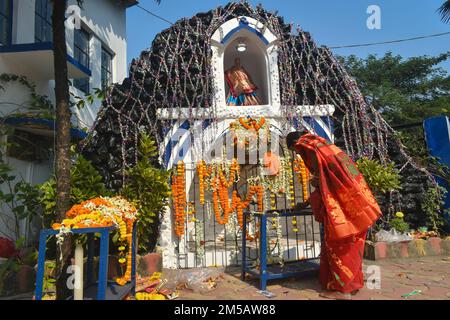 Kalkutta, Indien. 25. Dezember 2022. Am 25. Dezember 2022 stellt eine Frau am Stadtrand von Kalkutta, Indien, zu Weihnachten Kerzen in eine Kirche. (Foto: Sudipta das/Pacific Press/Sipa USA) Guthaben: SIPA USA/Alamy Live News Stockfoto