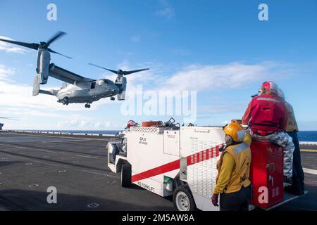 PAZIFIK (16. Februar 2022) Seeleute, die dem Amphibienschiff USS Essex (LHD 2) der Wasp-Klasse zugeteilt sind, beobachten einen Fischadler MV-22B, der an der Marine Medium Tiltrotor Squadron (VMM) 165 (verstärkt) befestigt ist; 11. Marine Expeditionary Unit (MEU) aus einem mobilen Löschfahrzeug der P-25A als Teil des Aufprall- und Bergungsteams an Bord von Essex während des Flugbetriebs, 16. Februar 2022. Matrosen und Marines der Essex Amphibious Ready Group (ARG) und der 11. MEU führen derzeit Routineeinsätze in der US-3.-Flotte durch. Stockfoto