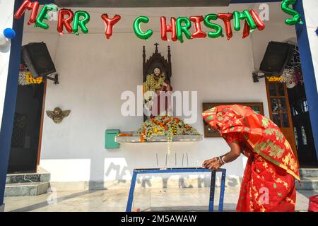 Kalkutta, Indien. 25. Dezember 2022. Am 25. Dezember 2022 stellt eine Frau am Stadtrand von Kalkutta, Indien, zu Weihnachten Kerzen in eine Kirche. (Foto: Sudipta das/Pacific Press/Sipa USA) Guthaben: SIPA USA/Alamy Live News Stockfoto