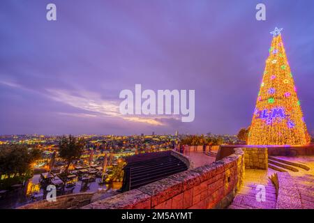 Abendlicher Blick auf einen Weihnachtsbaum auf dem Scopus und die Altstadt im Hintergrund in Jerusalem, Israel Stockfoto
