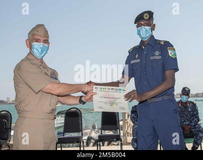 DSCHIBUTI, Dschibuti (17. Februar 2022) – USA Mark Haigis, stellvertretender Befehlshaber des Navy Expeditionary Combat Command, legt Ali Mohamed Ali, einem Mitglied der dschibutischen Küstenwache, während der Abschlusszeremonien der Übung Cutlass Express 2022 am Dschibuti-Marinepier Dschibuti, Dschibuti, am 17. Februar eine Abschlussbescheinigung vor. Cutlass Express 2022, gesponsert von U.S. Afrika-Kommando und von den USA durchgeführt Die Marinekräfte Afrika sollen die regionale Zusammenarbeit zwischen den teilnehmenden Ländern verbessern, um die Sicherheit und Gefahrenabwehr im Seeverkehr in den Regionen Ostafrikas zu erhöhen. Stockfoto