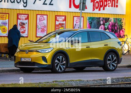 Göteborg, Schweden - Oktober 03 2022: Gelber Elektrowagen Volkswagen ID4 Pro, der an einem Geschäft geparkt ist Stockfoto