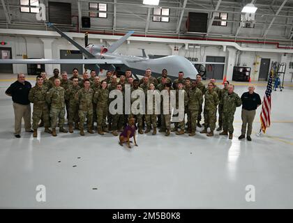 34 Soldaten der New Yorker Nationalgarde und Airmen absolvieren am 17. Februar 2022 eine medizinische Notfallausbildung an der Hancock Air National Guard Basis in Syracuse, New York. Zivile Trainer und Wächter posieren für ein Abschlussfoto vor dem Sensenmann MQ-9. Sie gehören zu den 400, die zusätzlich zu ihren militärischen Fähigkeiten als Rettungssanitäter ausbilden, im Rahmen einer Initiative unter der Leitung von New Yorker Gouverneur Kathy Hochul. Stockfoto