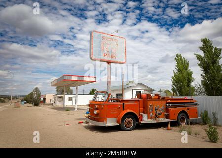 Ein altes Feuerwehrauto von Fort Sumner befindet sich neben dem verlassenen Sundown RV Park an der Route 66 in der Nähe von Santa Rosa, New Mexico. Stockfoto