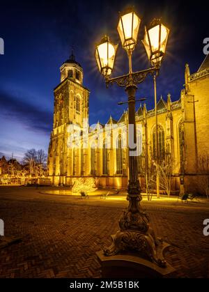 Eine Vertikale einer hellen Straßenlaterne am historischen Wahrzeichen Nieuwe Toren in Kampen, Niederlande Stockfoto