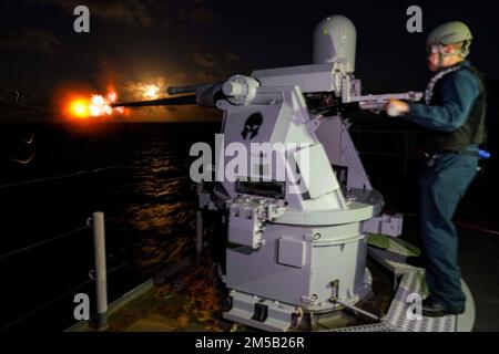 PACIFIC OCEAN (17. Februar 2022) Fire Controlman 2. Class Walter Pan, ein Einheimischer aus Kansas City, Kansas, feuert eine Mark 38 25 mm Maschinenpistole vom Deck des Amphibiendock-Landungsschiffs USS Pearl Harbor (LSD 52) der Harpers Ferry-Klasse ab, während eine Crew im Pazifik Waffenschüsse abgab, 17. Februar 2022. Matrosen und Marines der Essex Amphibious Ready Group (ARG) und der 11. Marine Expeditionary Unit (MEU) führen derzeit Routineeinsätze in der US-amerikanischen 3.-Flotte durch. Stockfoto