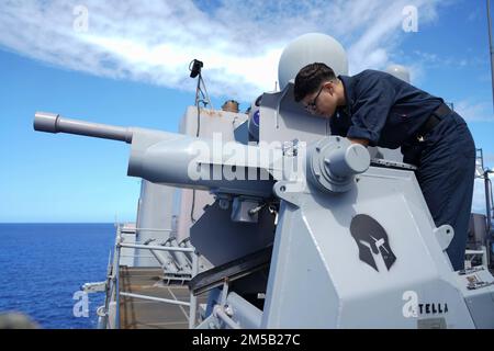 PACIFIC OCEAN (17. Februar 2022) Gunner's Mate 3. Class Marayah Camacho, ein Einheimischer aus Tucson, Ariz., reinigt die Halterung eines Mark 38 25 mm Maschinengewehrs an Bord des Amphibiendock-Landungsschiffs USS Pearl Harbor (LSD 52) der Harpers Ferry-Klasse, während eine Crew im Pazifik Waffenschießeisen abgab; 17. Februar 2022. Matrosen und Marines der Essex Amphibious Ready Group (ARG) und der 11. Marine Expeditionary Unit (MEU) führen derzeit Routineeinsätze in der US-amerikanischen 3.-Flotte durch. Stockfoto