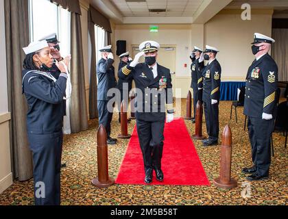 Kapitän Brian Hogan, commodore, U-Boot-Geschwader (COMSUBRON) Acht, grüßt die Sideboys, die am Freitag, den 18. Februar, die Zeremonie zur Wiederaufnahme seines Kommandos am Marinestützpunkt Norfolk verlassen. Die Wiederaufnahme von COMSUBRON Acht soll die Verantwortung für die Führung und Kontrolle der U-Boote, die dem Befehlshaber der U-Boot-Staffel 6 mit Sitz in Norfolk, VA, während der Instandhaltungsphase der U-Boote und der Instandhaltungswerften zugewiesen wurde, verteilen und angleichen. Stockfoto