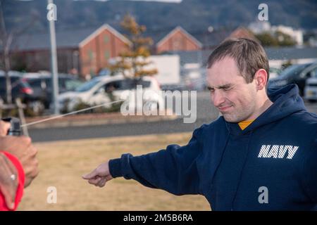 Chief Master-at-Arms Ezra Payton besprüht Damage Controlman 2. Klasse Douglas Audette mit Oleoresin Capsicum (OC) Spray während des nicht-tödlichen Waffentrainings der Hilfssicherheitskräfte (ASF) bei der CFAS am 18. Februar 2022. Das Personal der ASF nimmt an einem vierwöchigen Ausbildungslehrgang Teil, um sich während der Bedingungen für den verstärkten Schutz der Streitkräfte oder auf Anweisung des Befehlshabers der Anlage als Aufsteiger der Sicherheitskräfte der Marine einer Anlage zu qualifizieren. Stockfoto