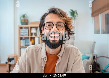 Porträt eines Freiberuflers im Heimbüro, der vor der Kamera lächelt. Glücklicher Unternehmer. Stockfoto