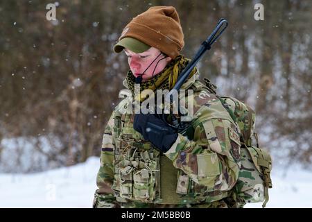 Staff Sgt. Sydney Whiteis, ein Verteidiger der 934. Sicherheitsstaffel in Minneapolis-St. Paul Air Reserve Station, hört ihr Radio, während ihre Studenten des Integrated Defense Leadership Kurses eine gegnerische Position im Camp James A. Garfield Joint Military Training Center, 18. Februar 2022, angreifen. Whiteis diente während des IDLC als Cadre-Mitglied, einer intensiven, zweiwöchigen, praxisorientierten Lernerfahrung, die Reserve Defenders helfen soll, Kampfbereitschaft zu erreichen und aufrechtzuerhalten. (USA Air Force Photo/Eric M. White) Stockfoto