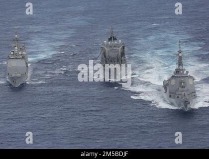 PHILIPPINE SEA (20. Februar 2022) Japan Maritime Self-Defense Force (JMSDF) Nachfüllöler JS Towada-Klasse (AOE 422), Mitte, betankt Guided-Missile Cruiser der Ticonderoga-Klasse USS Mobile Bay (CG 53), links, während JMSDF Guided-Missile Destroyer JS Myoko (DDG 175) wegsegelt. Die Abraham Lincoln Strike Group befindet sich in einem geplanten Einsatz im US-7.-Flottenbereich, um die Interoperabilität durch Allianzen und Partnerschaften zu verbessern und gleichzeitig als einsatzbereite Truppe zur Unterstützung einer freien und offenen Region Indo-Pacific zu fungieren. Stockfoto