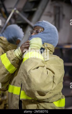 NEWPORT NEWS, VA (22. Februar 2022) – Aviation Maintenance Administrationman 2. Class Brya V. Russell aus Milwaukee, der Abteilung für die mittlere Instandhaltung von Flugzeugen an Bord des Flugzeugträgers USS George Washington der Nimitz-Klasse (CVN 73) zugewiesen wurde, hat während einer allgemeinen Quartierübung ein Feuerlöschensemble. George Washington wird bei Newport News Shipyard den Tankkomplex überholen (RCOH). RCOH ist ein mehrjähriges Projekt, das nur einmal während der 50-jährigen Lebensdauer eines Frachtführers durchgeführt wird und das Betanken der beiden Kernreaktoren des Schiffs sowie erhebliche Reparaturen, Aufrüstungen und Verkehrsträger umfasst Stockfoto