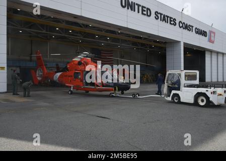 USA Küstenwachmänner, die der Luftwaffenstation der Küstenwache in Savannah, Georgia, zugewiesen wurden, führen einen MH-65 Dolphin Helikopter in den Hangar, 21. Februar 2022. Der Verantwortungsbereich der Air Station Savannah erstreckt sich über eine etwa 450 km lange Küstenlinie von der nördlichen Grenze von South Carolina nach Melbourne, Florida. Stockfoto