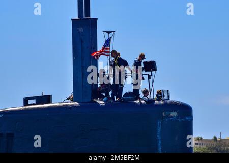 APRA-HAFEN, Guam (21. Februar 2022) Seeleute, die dem Schnellangriff-U-Boot USS Asheville (SSN 758) der Los Angeles-Klasse zugeteilt sind, dem Kommandanten der U-Boot-Staffel (CSS) 15 zugeteilt sind, kommunizieren auf der Brücke, während sie sich auf den Abflug der Marinebasis Guam für einen Routineeinsatz vorbereiten. Asheville wird während des Indo-Pazifik-Einsatzes ein vollständiges Spektrum von Operationen durchführen, einschließlich U-Boot- und oberflächenabwehrender Kriegsführung. Stockfoto