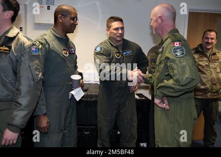 USA Oberstleutnant Jeremy Stover, Mitte links, 420. Geschwader der Luftwaffe und 420. Befehlshaber der Luftwaffe der Expeditionsbasis, begrüßt die kanadische Armee Brigade. General Paul Doyle, rechts, MSM CD, Canada Commander und Defense Advisor, bei RAF Fairford, England, 21. Februar 2022. Die Tour, auf der diese Würdenträger und Gäste teilnahmen, sollte Repräsentanten aus den alliierten Nationen Einblicke in die Fähigkeiten und Operationen der USA geben Luftwaffe im Vereinigten Königreich. Stockfoto