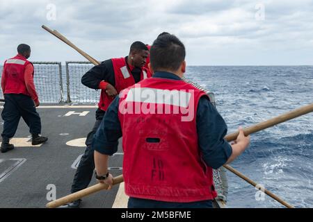 PHILIPPINISCHE SEE (22. Februar 2022) Seeleute senken die Netze auf dem Cockpit der Arleigh-Burke-Klasse-Guided-Missile Destruyer USS Spruance (DDG 111). Die Abraham Lincoln Strike Group befindet sich in einem geplanten Einsatz im US-7.-Flottenbereich, um die Interoperabilität durch Allianzen und Partnerschaften zu verbessern und gleichzeitig als einsatzbereite Truppe zur Unterstützung einer freien und offenen Region Indo-Pacific zu fungieren. Stockfoto