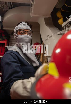 220222-N-GF276-1035 NEWPORT NEWS, VA (22. Februar 2022) – Aviation Electronics Technician 3. Class Aukeviah J. D. Thornton aus Elleville, Georgia, zugewiesen in die Abteilung für die mittlere Instandhaltung von Flugzeugen, an Bord des Flugzeugträgers der Nimitz-Klasse USS George Washington (CVN 73) gibt während einer allgemeinen Quartierübung einen Feuerwehrhelm aus. George Washington wird bei Newport News Shipyard den Tankkomplex überholen (RCOH). RCOH ist ein mehrjähriges Projekt, das nur einmal während der 50-jährigen Lebensdauer eines Frachtführers durchgeführt wird und die Betankung der beiden Kernreaktoren des Schiffs sowie Signifi umfasst Stockfoto