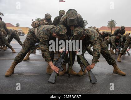 USA Marinekorps rekrutieren bei der Hotel Company, 2. Rekruten-Trainingsbataillon, stapeln ihre Waffen während einer Übung in der Rekrutierungsabteilung des Marinekorps in San Diego, 23. Februar 2022. Die Bohrmeister bewerteten die Platoons anhand von Uniformen, militärischer Peilung und Bewegungen. Die Übung zum Geschäftsabschluss ist ein wichtiges Mittel, mit dem ein Rekrutierer einen hohen Grad an Disziplin, Selbstvertrauen und Respekt für Autorität, Teamarbeit, Teamgeist und sofortige Bereitschaft entwickelt, Befehle zu befolgen. . Stockfoto