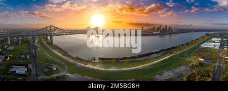 Panoramablick auf die Innenstadt von New Orleans, den Mississippi und die Crescent City Connection Bridge mit farbenfrohem Sonnenuntergang Stockfoto