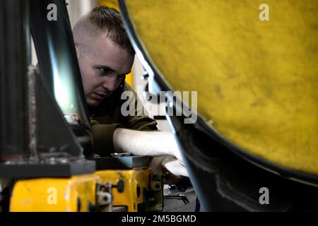 USA Air Force Staff Sgt. John Dilks, 177. Maintenance Group Motorenmechaniker, repariert einen Motor, während das erste Production Assessment Team der Air National Guard am 22. Februar 2022 im 177. Kampfflügel der New Jersey Air National Guard, Egg Harbor Township, New Jersey, auftaucht. Ziel des Production Assessment Teams ist es, die Anzahl der Flugzeuge zu erhöhen, die eine Einheit in den Kampf bringen kann, und sich dabei auf die Aspekte der Verfügbarkeit von Flugzeugen zu konzentrieren, die die Einheiten kontrollieren können – wie gut und wie schnell sie Flugzeuge reparieren und wie reibungslos sie planmäßige Wartungsarbeiten durchführen. Stockfoto