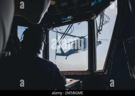 220222-N-GF955-1005 KARIBISCHES MEER - (21. Februar 2022) -- Boatswain’s Mate 1. Klasse Emmanuel Dixon zugeordnet zum Freiheitsvarianten-Küstenkampfschiff USS Billings (LCS 15) beobachtet vom Flugkontrollturm aus als MH-60s Sea Hawk Hubschrauber, der dem ‚Shadow Det‘ des Hubschraubers Sea Combat Squadron (HSC) 28, Einheit 7, startet vom Flugdeck, 21. Februar 2022. Billings wird in das US-Flottengebiet 4. entsandt, um die Mission der Joint Interagency Task Force South zu unterstützen, zu der auch Missionen zur Bekämpfung des illegalen Drogenhandels in der Karibik und im östlichen Pazifik gehören. Stockfoto