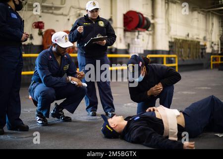 220222-N-CZ759-1162 SAN DIEGO (22. Februar 2022) – Seeleute nehmen an einer Übung eines medizinischen Trainingsteams an Bord des Amphibienschiffs USS Tripoli (LHA 7) am 22. Februar Teil. Tripolis ist ein Amphibienschiff der amerikanischen Klasse, das in San Diego Homeportiert ist. Stockfoto