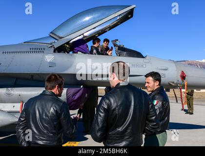 Italienische Frecce Tricolori Aerobatic-Teammitglieder aus dem Luftwaffenstützpunkt Rivolto, Italien, sehen sich einen F-16 Fighting Falcon auf einer Führung am Stützpunkt Aviano, Italien, am 22. Februar 2022 an. Das Team besichtigte den 510. FS, schaute sich einen F-16 an und nahm an Flugsimulationen Teil. Diese Besuche bauen Beziehungen auf und stärken vertrauenswürdige Partnerschaften zwischen Italien und den Vereinigten Staaten. Stockfoto