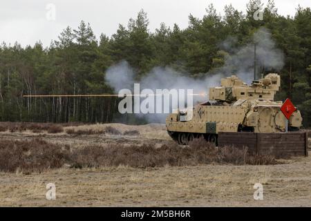 EIN US-AMERIKANISCHER Army m2 Bradley Infanterie-Kampffahrzeug zugewiesen zum 1. Geschwader, 4. Kavallerie-Regiment, 1. Panzerbrigade-Kampfteam, 1. Infanterie-Division feuert ihre Waffe auf Trzebien, Polen, 22. Februar 2022. Die 1-4 durchführte den Table V-Schießtisch, in dem die Panzerbesatzung darin geschult wird, in taktischen Arrays stationäre und bewegliche Ziele von einem stationären und beweglichen Panzer mit panzermontierten automatischen Waffen sowohl bei Tag als auch bei Nacht anzugreifen. Stockfoto