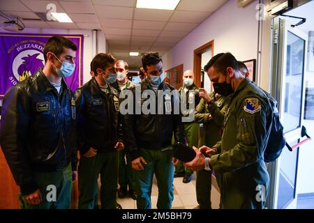 Mitglieder des italienischen Frecce Tricolori-Aerobatikteams besichtigen die 510. Kampfgeschwader auf dem Luftwaffenstützpunkt Aviano, Italien, am 22. Februar 2022. Im Rahmen des Besuchs besichtigte das Team den Luftwaffenstützpunkt Aviano und schaute sich eine F-16 an, die der 510. Kampfstaffel zugewiesen wurde. Der Luftwaffenstützpunkt Rivolto befindet sich etwa 45 Minuten östlich des Luftwaffenstützpunkts Aviano. Stockfoto