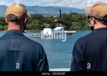 220221-N-VQ947-1044 PAZIFIK (21. Februar 2022) – Seeleute beobachten das USS Arizona Memorial vom Brückenflügel der Amphibien-Transportanlage USS Portland (LPD 27), 21. Februar 2022. Matrosen und Marines der Essex Amphibious Ready Group (ARG) und der 11. Marine Expeditionary Unit (MEU) besuchen die Joint Base Pearl Harbor-Hickam, während sie in der US-3.-Flotte tätig sind. Stockfoto