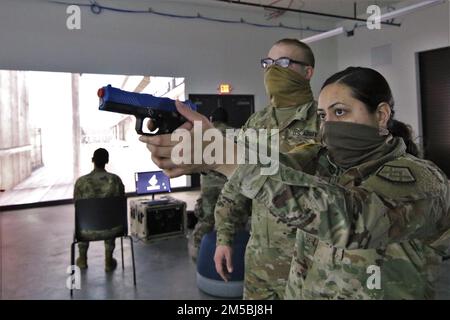 USA Army Reserve CPL. Cody Ort, zugewiesen zu 946. Transportation Company, 316. Sustainment Command, 377. Sustainment Command, Lewes, Del., Coacht Soldier 1.-Kollegin Julia Rocha, wie sie mit einem SIG Sauer P320 im Mobile Marksmanship Training Simulator im Simulationskomplex in Fort McCoy, Wisconsin, angreift, 23. Februar 2022. Ort ist Justizvollzugsbeamter. Das Unternehmen nahm an einer Reihe individueller Schulungsveranstaltungen Teil, um seine Bereitschaft im forst aufrechtzuerhalten, bevor es nach der Operation Allies Welcome Mission umschichtete. Stockfoto