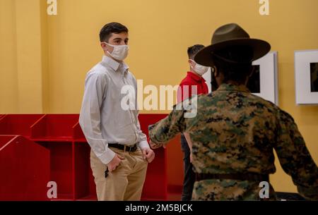 USA Marinekorps Gunnery Sgt. Vernita M. Finley, leitende Ausbilderin bei Empfangsfirma, Stützbataillon, rechts, beauftragt einen Rekruten, links, Während des Empfangs im Marine Corps Recruit Depot, San Diego, 22. Februar 2022. Zu dieser Zeit leerten die Rekruten ihre Taschen und ließen alles zur Untersuchung in den roten Mülleimern. Stockfoto