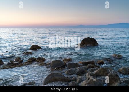 Wunderschöne Aussicht auf die orange Sonnenuntergangs-Seestücke mit Felsen in Italien. Tropische, farbenfrohe Landschaft bei Sonnenaufgang. Naturlandschaft. Tropische Küste Stockfoto