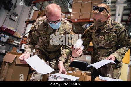 USA Air Force Staff Sgt. Michael Moss, 379. Expeditionary Medical Support Squadron Medical Logistics Flight Member (links), vertreibt Lieferungen in die USA Air Force Tech. Sgt. Rachel Little, 379. Mitglied der Expeditionary Aeromedical Evacuation Squadron (rechts), am Al Udeid Air Base, Katar, 22. Februar 2022. Der medizinische Logistikflug EMDSS 379. liefert medizinische Einheiten über die gesamte Anlage für ihre spezifischen Einsatzanforderungen. Stockfoto