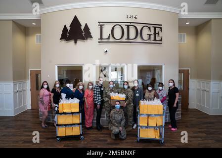 Reserve Citizen Airmen vom 413. Force Support Flight und Mitarbeiter der Lodge machen ein Gruppenfoto vom 23. Februar 2022 in Warner Robins, Georgia. Die Airmen spendeten 70 Beutel, eines für jeden Patienten, der sich derzeit in der Einrichtung befindet. Die Taschen enthielten Lotion, Lippenbalsam und andere Toilettenartikel sowie Aktivposten und Stifte. Die Lodge ist ein 2015 gegründetes Rehabilitationszentrum, das subakute Übergangsversorgung, qualifizierte Pflege und Langzeitpflege bietet. Stockfoto