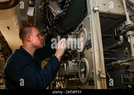 PHILIPPINE SEA (24. Februar 2022) Electrician's Mate Fireman Kendall Ptacnik aus Amarillo, Texas, prüft Drähte auf Kurzschlüsse an Bord des Flugzeugträgers USS Abraham Lincoln der Nimitz-Klasse (CVN 72). Die Abraham Lincoln Strike Group befindet sich in einem geplanten Einsatz im US-7.-Flottenbereich, um die Interoperabilität durch Allianzen und Partnerschaften zu verbessern und gleichzeitig als einsatzbereite Truppe zur Unterstützung einer freien und offenen Region Indo-Pacific zu fungieren. Stockfoto