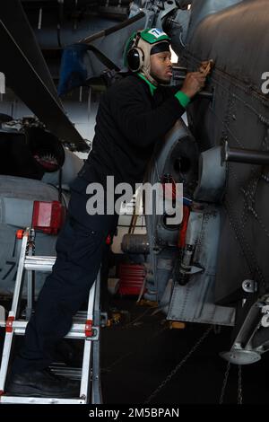 220224-N-QI593-1005 ADRIATIC SEA (24. Februar 2022) Aviation Structural Mechanic Airman Maleek Barnett aus New York, zugewiesen an die „Stolzen Krieger“ des Helicopter Maritime Strike Squadron (HSM) 72, entfernt Korrosion von einem MH-60R Sea Hawk Hubschrauber in der Hangarbucht des Flugzeugträgers der Nimitz-Klasse USS Harry S. Truman (CVN 75), 24. Februar 2022. Die Harry S. Truman Carrier Strike Group befindet sich in einem geplanten Einsatz in den USA Sechster Flottenbereich zur Unterstützung der Interessen der USA, Verbündeten und Partner in Europa und Afrika. Stockfoto