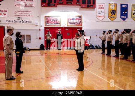 220224-N-PW480-0679 North Chicago, Illinois (24. Februar 2022) Fond-ADM. Jennifer Couture, Kommandeur des Naval Service Training Command (NSTC), erhält anlässlich des Besuchs des NJROTC-Standorts von Couture am 24. Februar einen Salut vom North Chicago Community High School Navy Junior Reserve Officer Training Command (NJROTC), Kadett Martha Castro. Couture und ihr NSTC-Personal mit Hauptsitz in Naval Station Great Lakes, Illinois, beaufsichtigen 583 NJROTC- und 58 Navy National Defense Cadet Corps (NNDCC)-Einheiten in allen Ländern und auf der ganzen Welt. Stockfoto